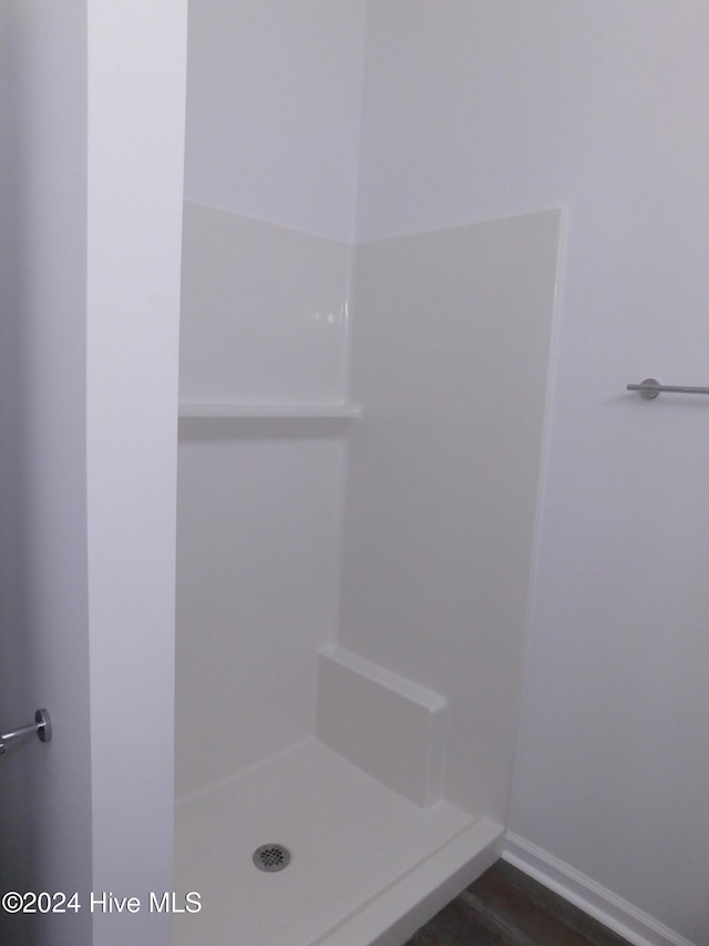 bathroom with hardwood / wood-style flooring and a shower