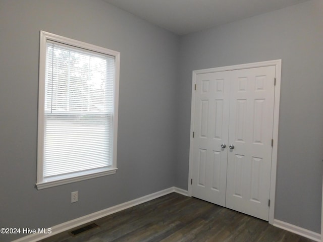 12521 Mckinnon Dr, Laurinburg, NC 28352 - unfurnished bedroom featuring dark wood-type flooring and a closet