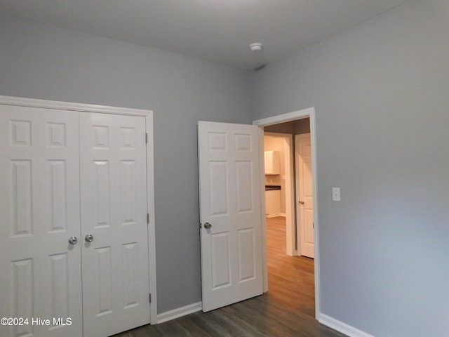 unfurnished bedroom with a closet and dark hardwood / wood-style flooring