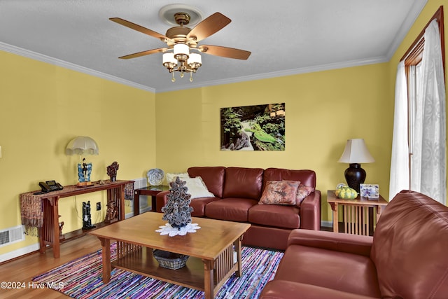 living room with hardwood / wood-style flooring, ceiling fan, and crown molding