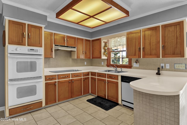 kitchen featuring sink, kitchen peninsula, crown molding, white appliances, and decorative backsplash