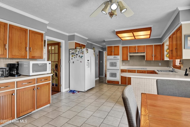 kitchen with decorative backsplash, crown molding, sink, and white appliances