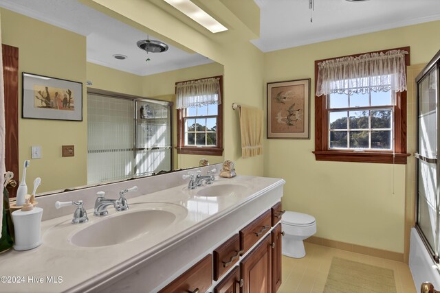 full bathroom featuring bath / shower combo with glass door, vanity, a healthy amount of sunlight, and toilet