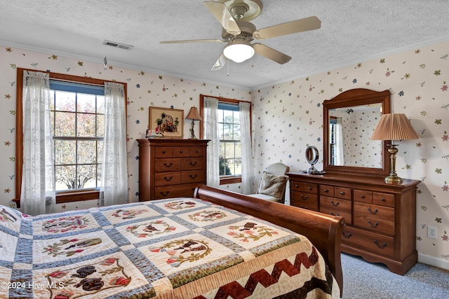 bedroom featuring ceiling fan, light colored carpet, a textured ceiling, and multiple windows