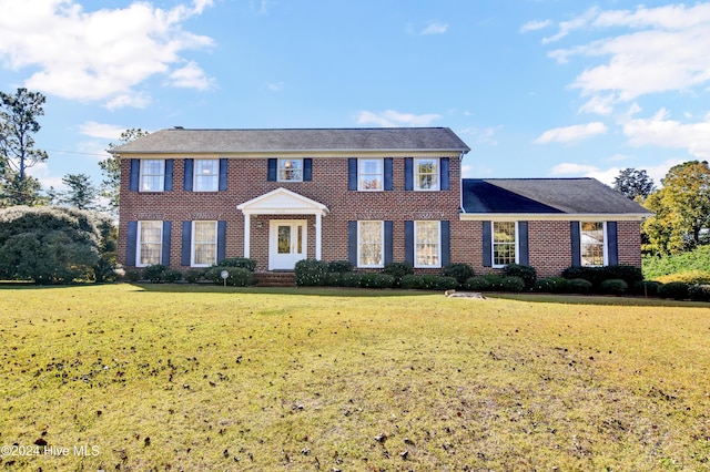 colonial house featuring a front lawn