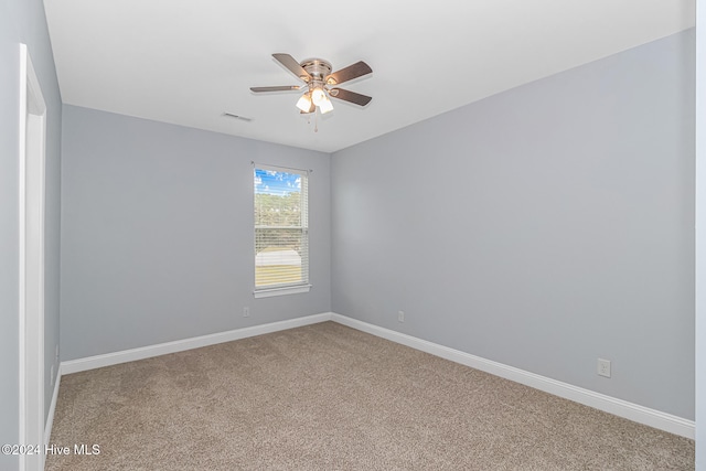 carpeted spare room featuring ceiling fan