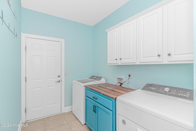 washroom featuring cabinets, light tile patterned floors, and washer and dryer