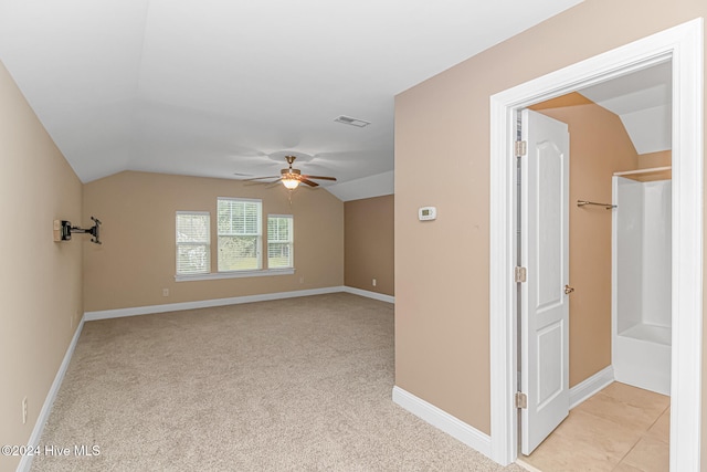 carpeted spare room with ceiling fan and lofted ceiling