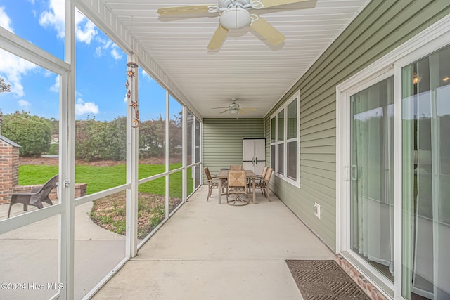 unfurnished sunroom with ceiling fan and plenty of natural light