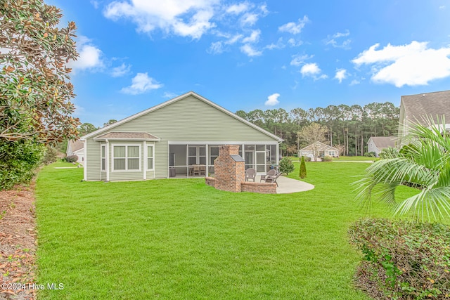 rear view of house featuring a patio, a lawn, and a sunroom