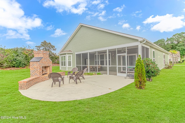 back of property featuring a lawn, a patio area, a sunroom, and a fireplace