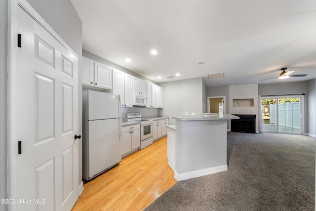 kitchen featuring a center island, white appliances, ceiling fan, light wood-type flooring, and white cabinetry