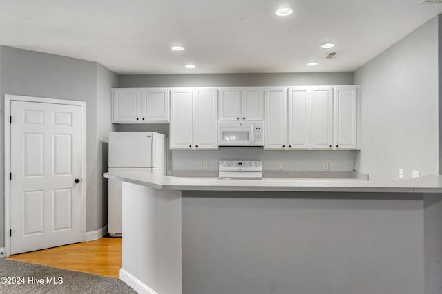 kitchen with white cabinetry, light wood-type flooring, white appliances, and kitchen peninsula