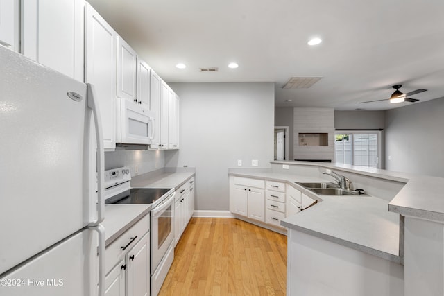 kitchen featuring white cabinetry, sink, white appliances, and light wood-type flooring