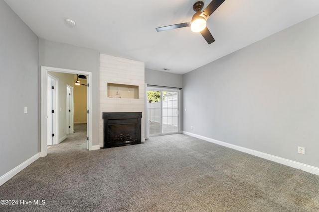 unfurnished living room featuring carpet flooring, ceiling fan, and a large fireplace