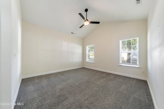 spare room with ceiling fan, plenty of natural light, and dark colored carpet