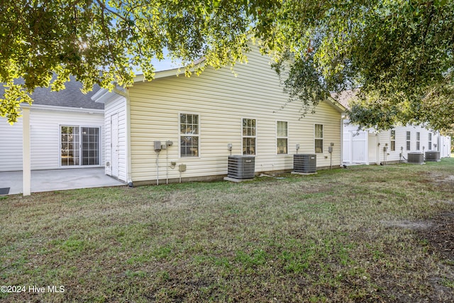 back of property with a yard, cooling unit, and a patio area