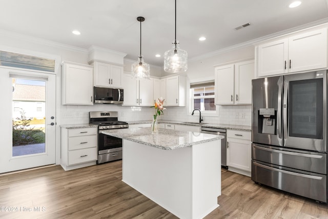 4067 Reunion Pointe Ln, New Bern, NC 28562 - kitchen with stainless steel appliances, a sink, plenty of natural light, white cabinetry, and crown molding
