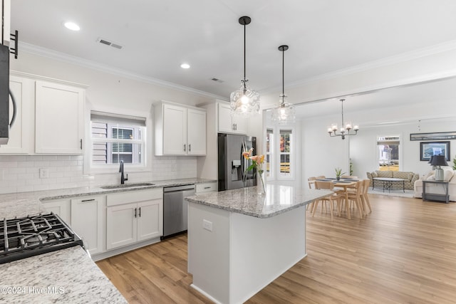 kitchen with sink, white cabinets, a kitchen island, and appliances with stainless steel finishes