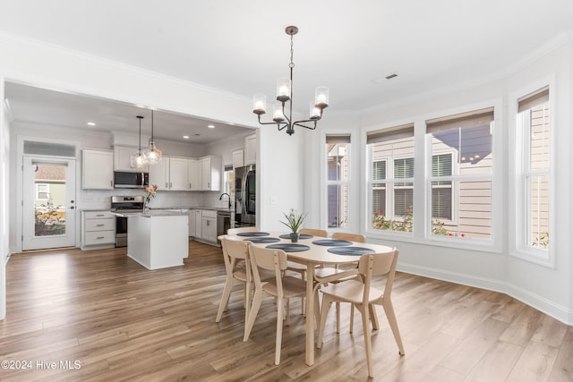4067 Reunion Pointe Ln, New Bern, NC 28562 - dining area featuring a chandelier, ornamental molding, light wood-style floors, and baseboards