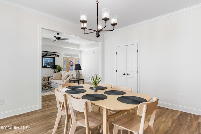 4067 Reunion Pointe Ln, New Bern, NC 28562 - dining area with light wood-style floors, a chandelier, baseboards, ceiling fan, and crown molding