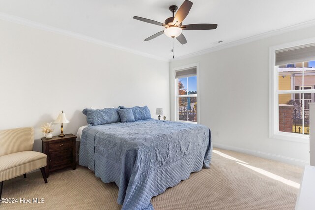 carpeted bedroom with ceiling fan and ornamental molding