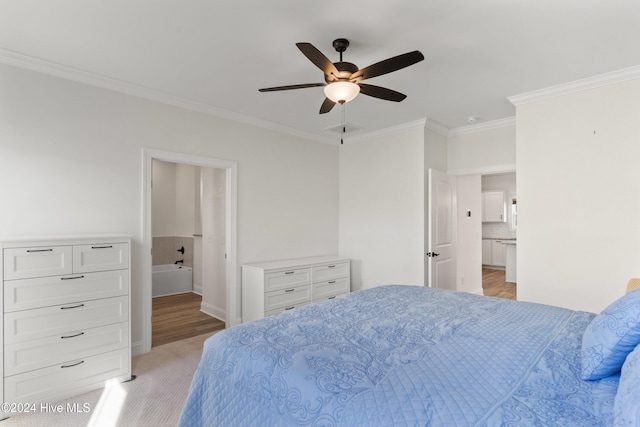 bedroom featuring ceiling fan, crown molding, light carpet, and ensuite bath