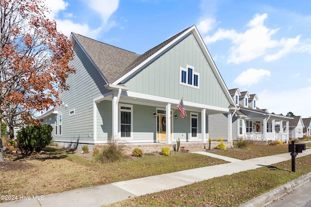 4067 Reunion Pointe Ln, New Bern, NC 28562 - view of front of home featuring a porch, board and batten siding, a front lawn, and roof with shingles