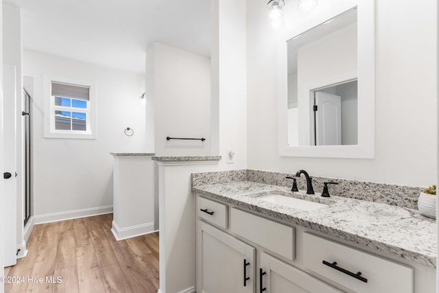 bathroom featuring hardwood / wood-style floors, vanity, and an enclosed shower