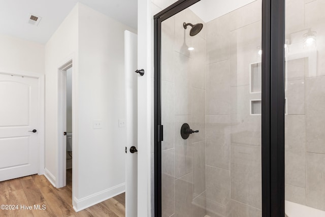 bathroom featuring hardwood / wood-style flooring and walk in shower