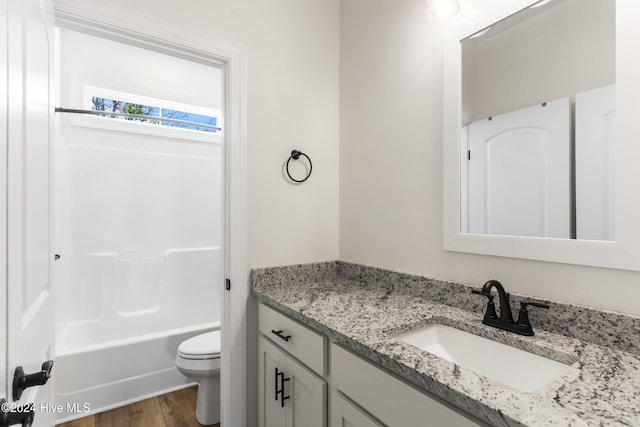 full bathroom with hardwood / wood-style floors, vanity, toilet, and shower / tub combination