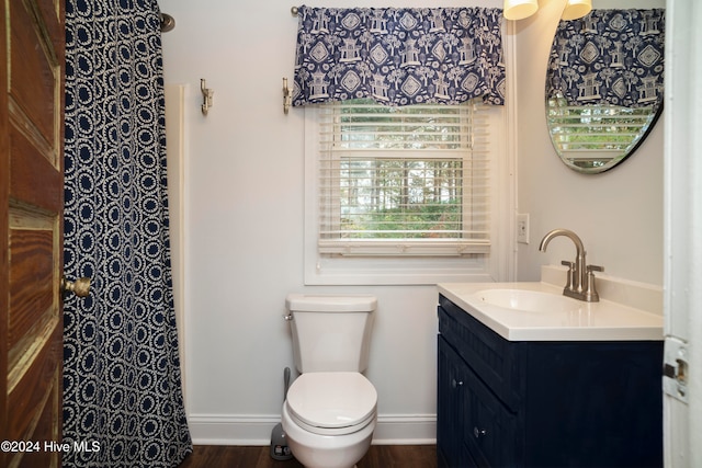 bathroom with toilet, vanity, and hardwood / wood-style flooring