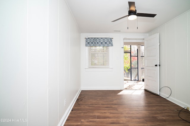 empty room featuring dark hardwood / wood-style floors, ceiling fan, and ornamental molding