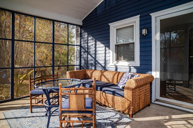 sunroom / solarium featuring vaulted ceiling