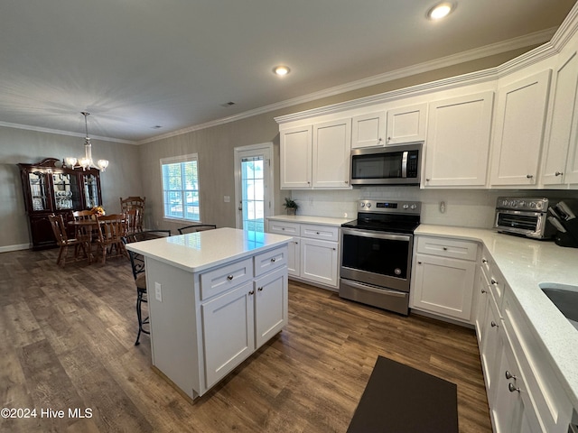 kitchen featuring dark wood-type flooring, white cabinets, stainless steel appliances, and a notable chandelier