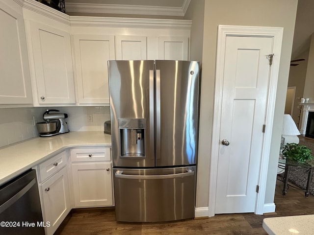 kitchen featuring backsplash, ornamental molding, stainless steel appliances, dark wood-type flooring, and white cabinetry