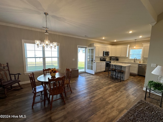 dining space with a chandelier, crown molding, dark wood-type flooring, and sink