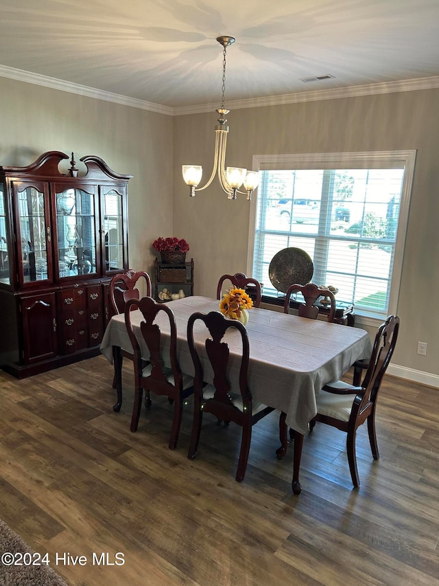 dining space featuring ornamental molding, dark wood-type flooring, and an inviting chandelier