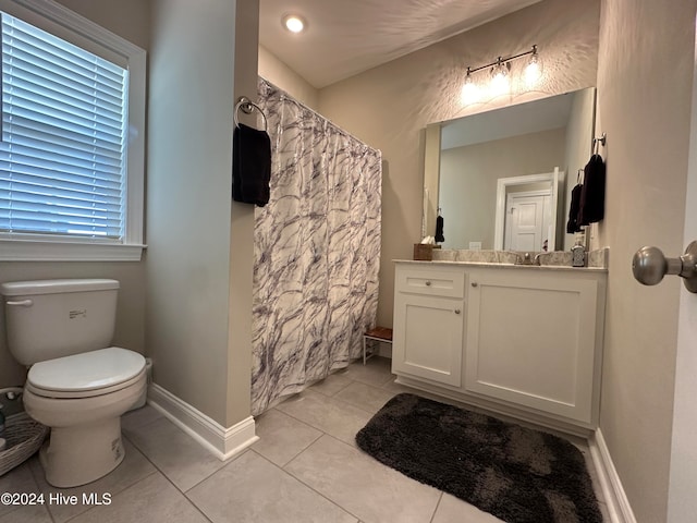 bathroom with tile patterned flooring, vanity, and toilet