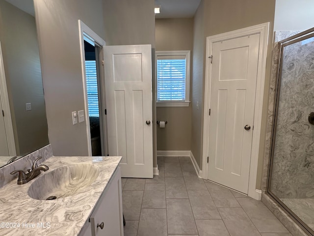 bathroom with vanity, tile patterned floors, and a shower with door