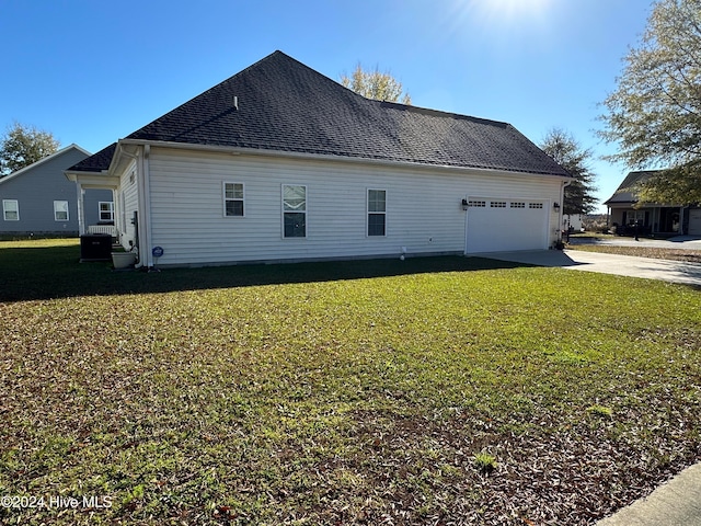 view of side of property featuring a lawn and a garage