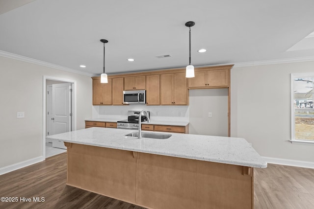 kitchen featuring a center island with sink, hanging light fixtures, and stainless steel appliances