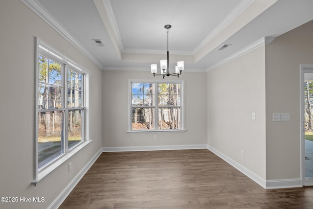 unfurnished dining area with a tray ceiling, dark wood-type flooring, ornamental molding, and a notable chandelier