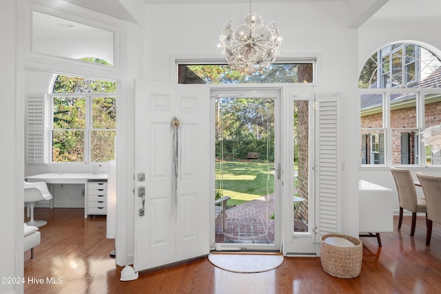 interior space with wood-type flooring, a wealth of natural light, and an inviting chandelier