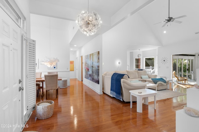 living room with hardwood / wood-style flooring, ceiling fan with notable chandelier, beamed ceiling, and high vaulted ceiling