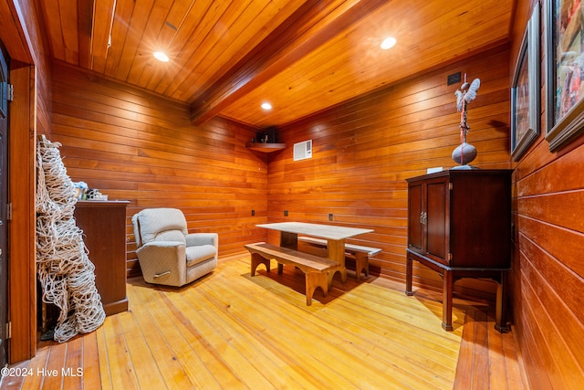 sitting room featuring beam ceiling, wooden walls, light hardwood / wood-style flooring, and wood ceiling