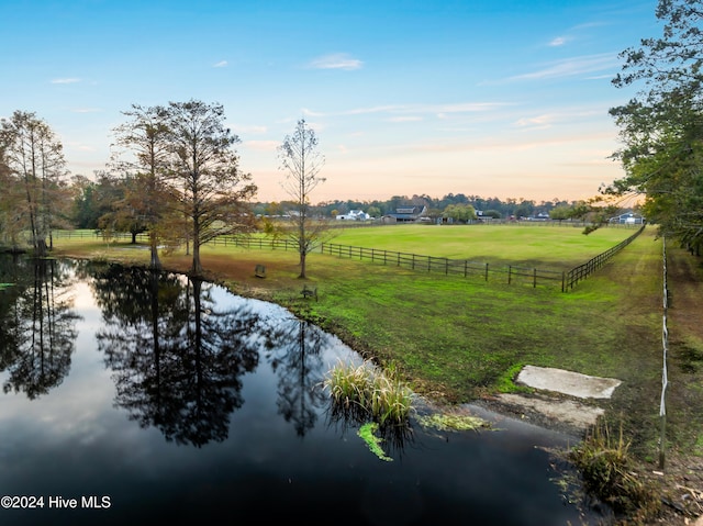 exterior space with a lawn, a water view, and a rural view