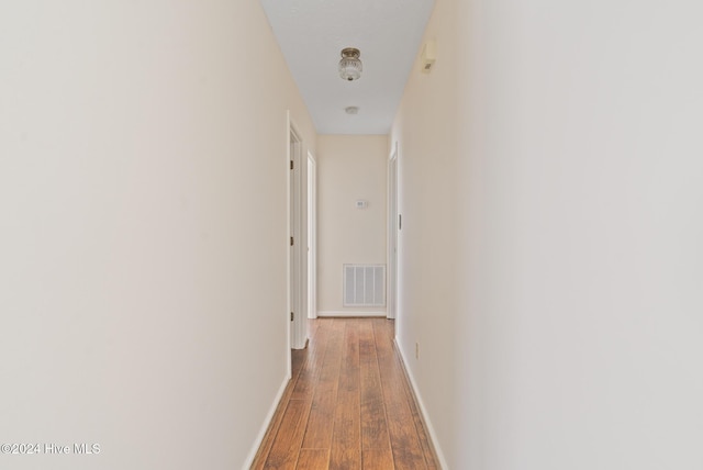 hallway with hardwood / wood-style floors