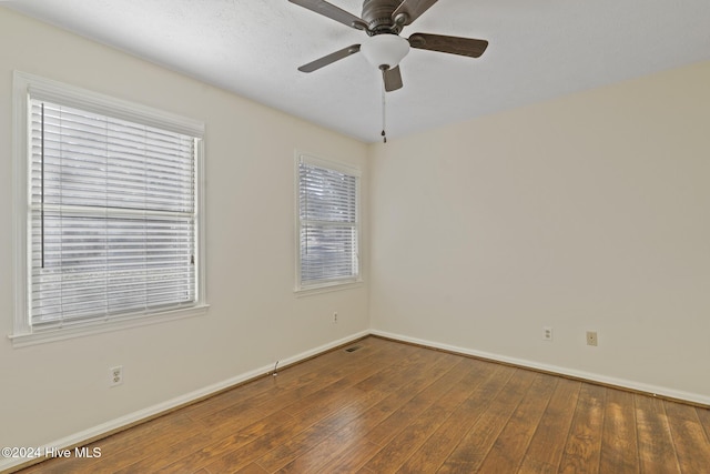 spare room with dark hardwood / wood-style floors and ceiling fan