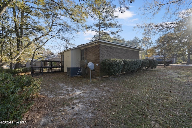 view of side of property with a deck and cooling unit